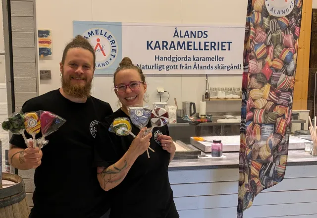 Anna och Obi håller klubbor framför karamellköket