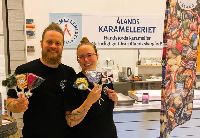 Obi och Anna står framför karamellköket och håller klubbor.